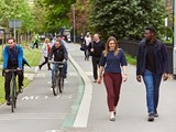 People walking and cycling down a street