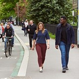 People walking and cycling down a street