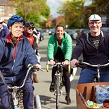 People cycling down a road