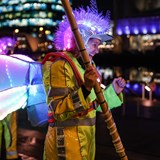 Woman wearing yellow hi vis, butterfly wings and light up helmet, entertaining people in Media City